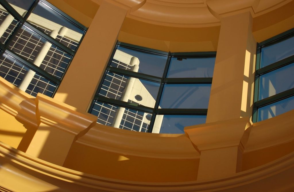 Curved glass windows reflecting the modern architectural details of a building.