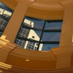 Curved glass windows reflecting the modern architectural details of a building.