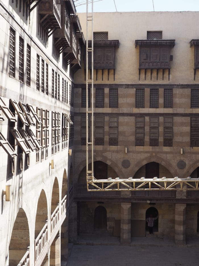 A historic courtyard featuring arched windows and traditional architectural design.